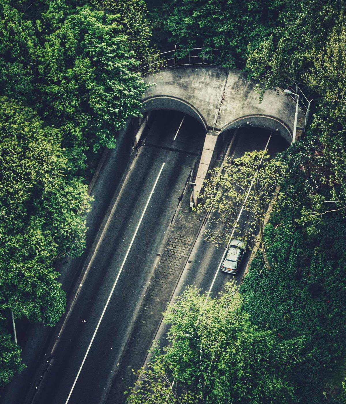 Aerial view of a road cutting through dense forest