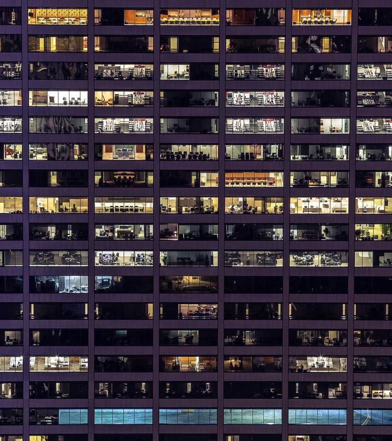 Lit office windows across a tower at night